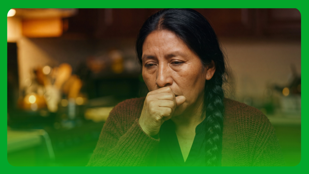 Woman coughing into her fist at home