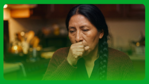 Woman coughing into her fist at home